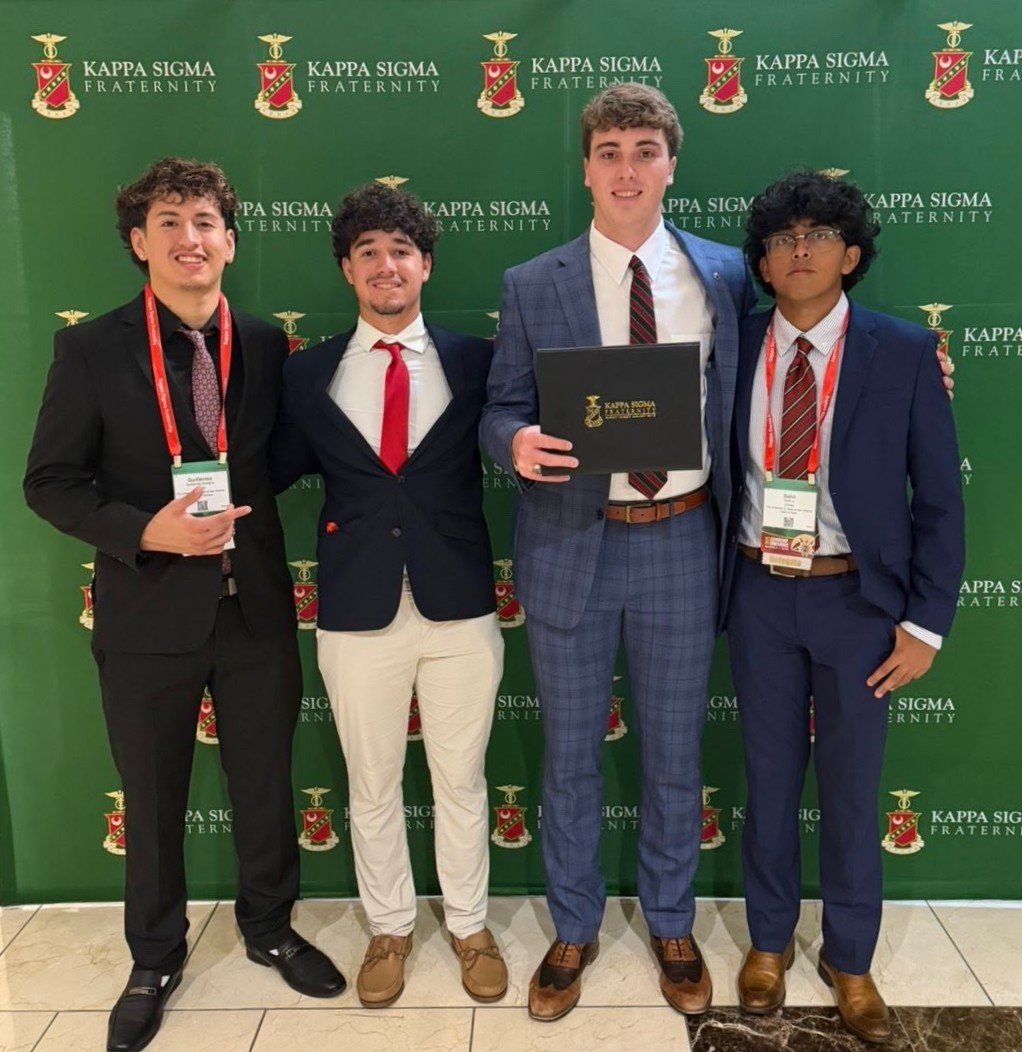 Four Xi-Delta brothers representing the chapter in suits